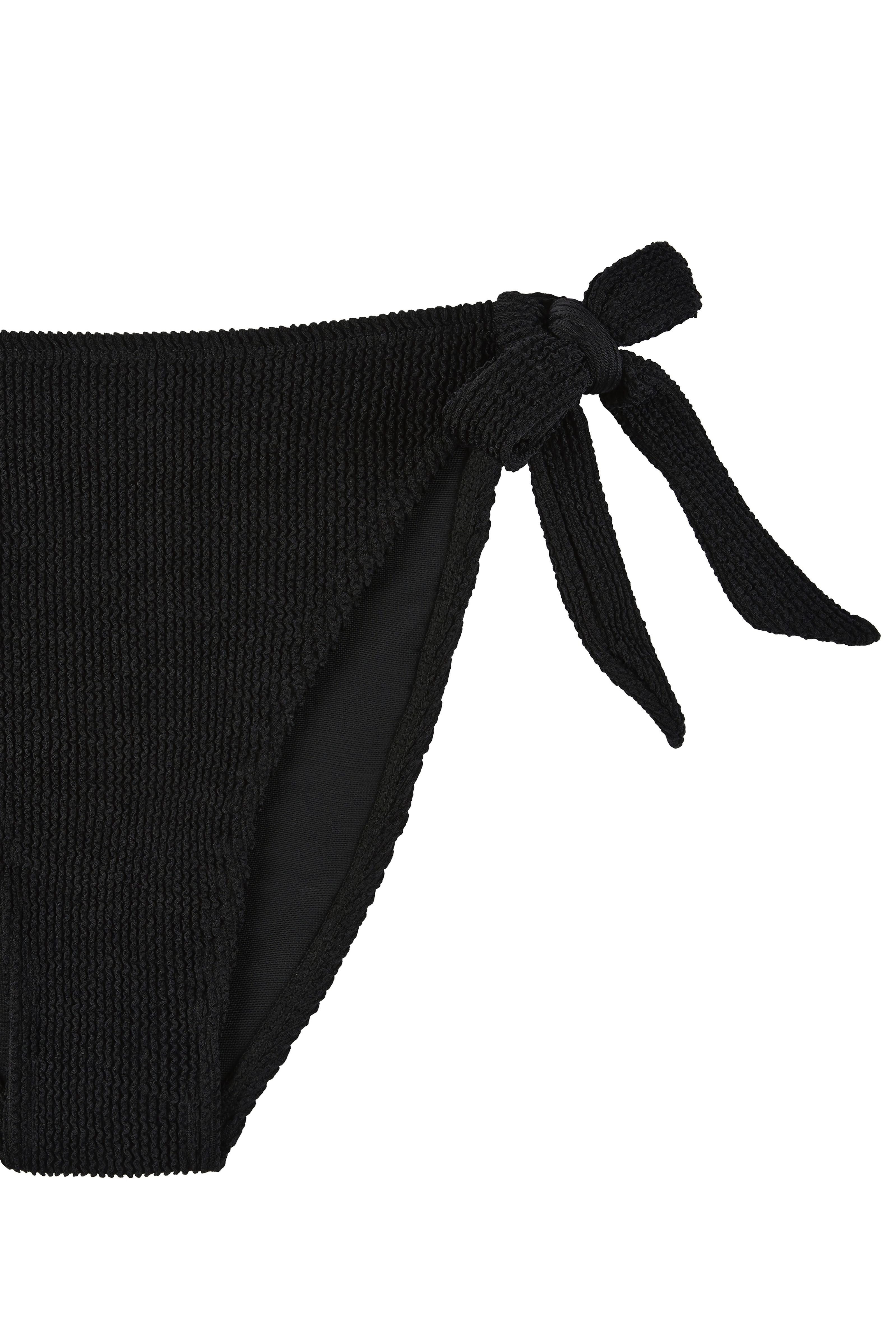 Flat lay side detail of the black Halo bikini bottoms showing the tie fastening