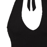 Flat lay of the black Haze swimsuit showing its halter tie and plunge V front