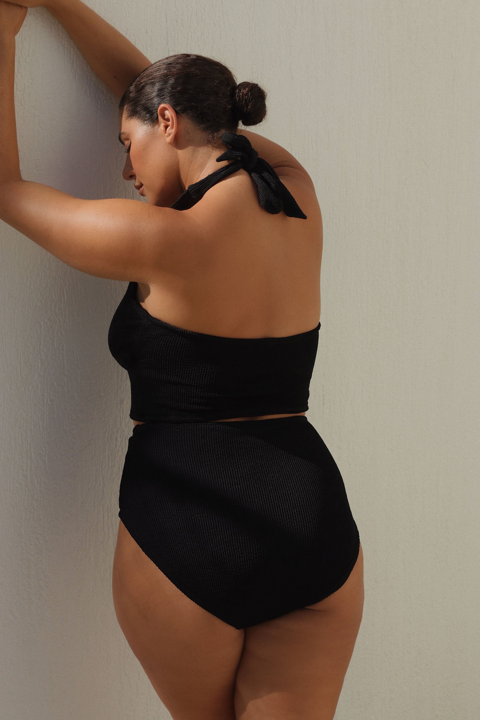 Black halter bikini top with built-in support, flattering plunge neckline and adjustable tie-neck.