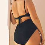 Full body view of black textured triangle bikini top and high-waisted bikini bottom set, showing curve-flattering silhouette.